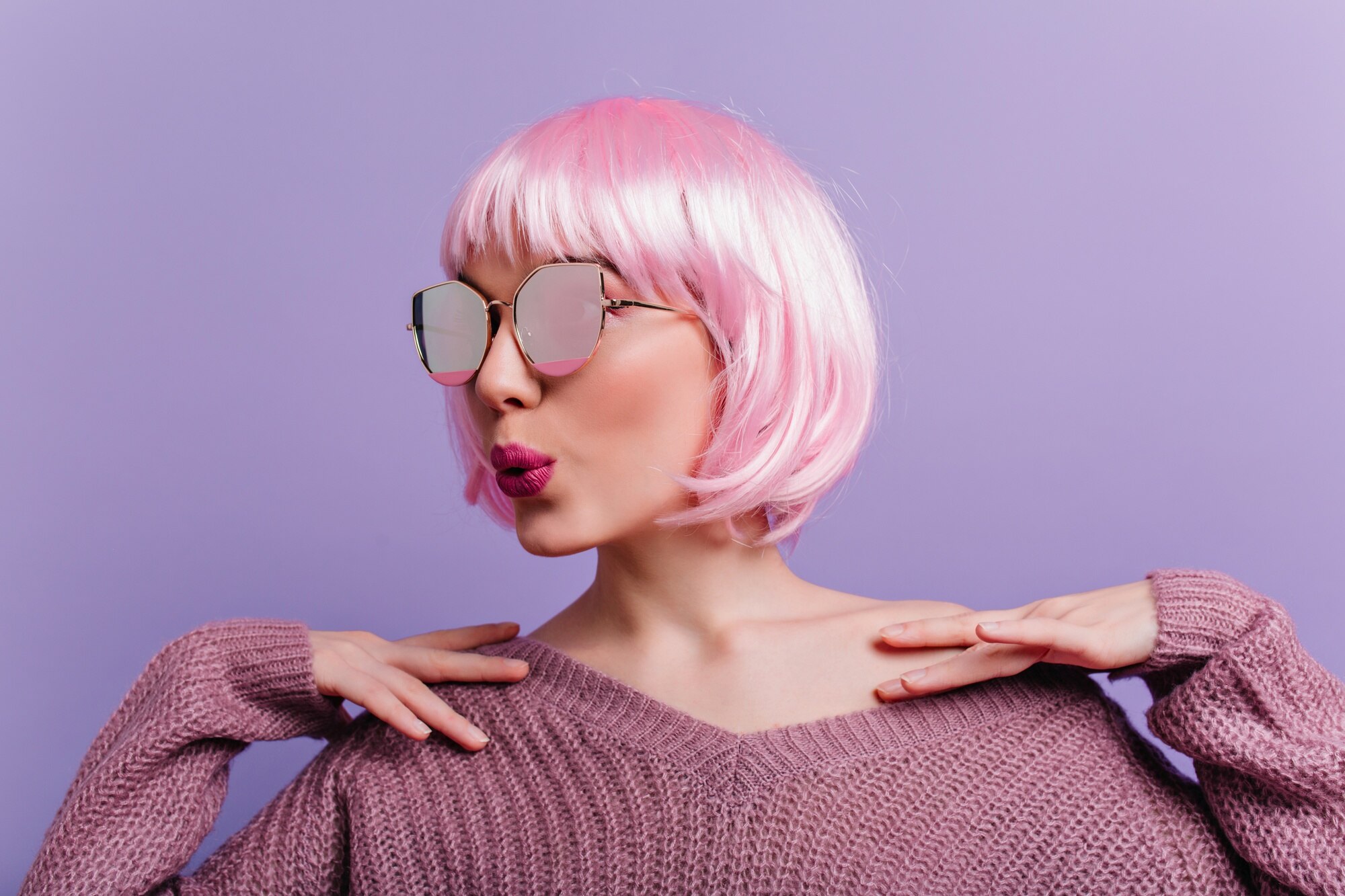 indoor-portrait-winsome-lady-sparkle-glasses-knitted-sweater-standing-purple-wall-photo-glamorous-girl-pink-wig-posing-with-kissing-face-expression_197531-8067